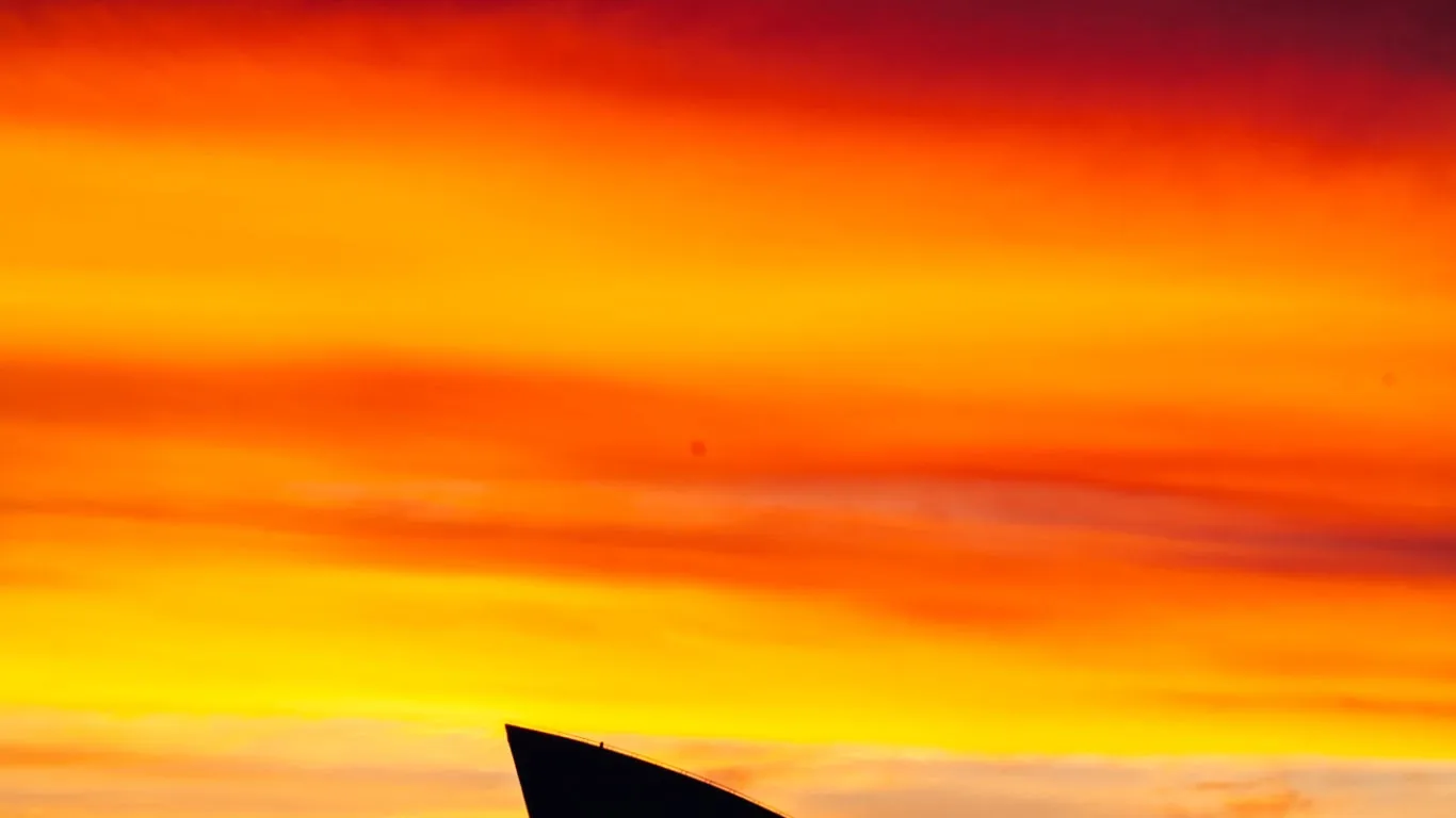 Sydney Opera House sails silhouetted against a red sunset — New South Wales solar and battery rebate information